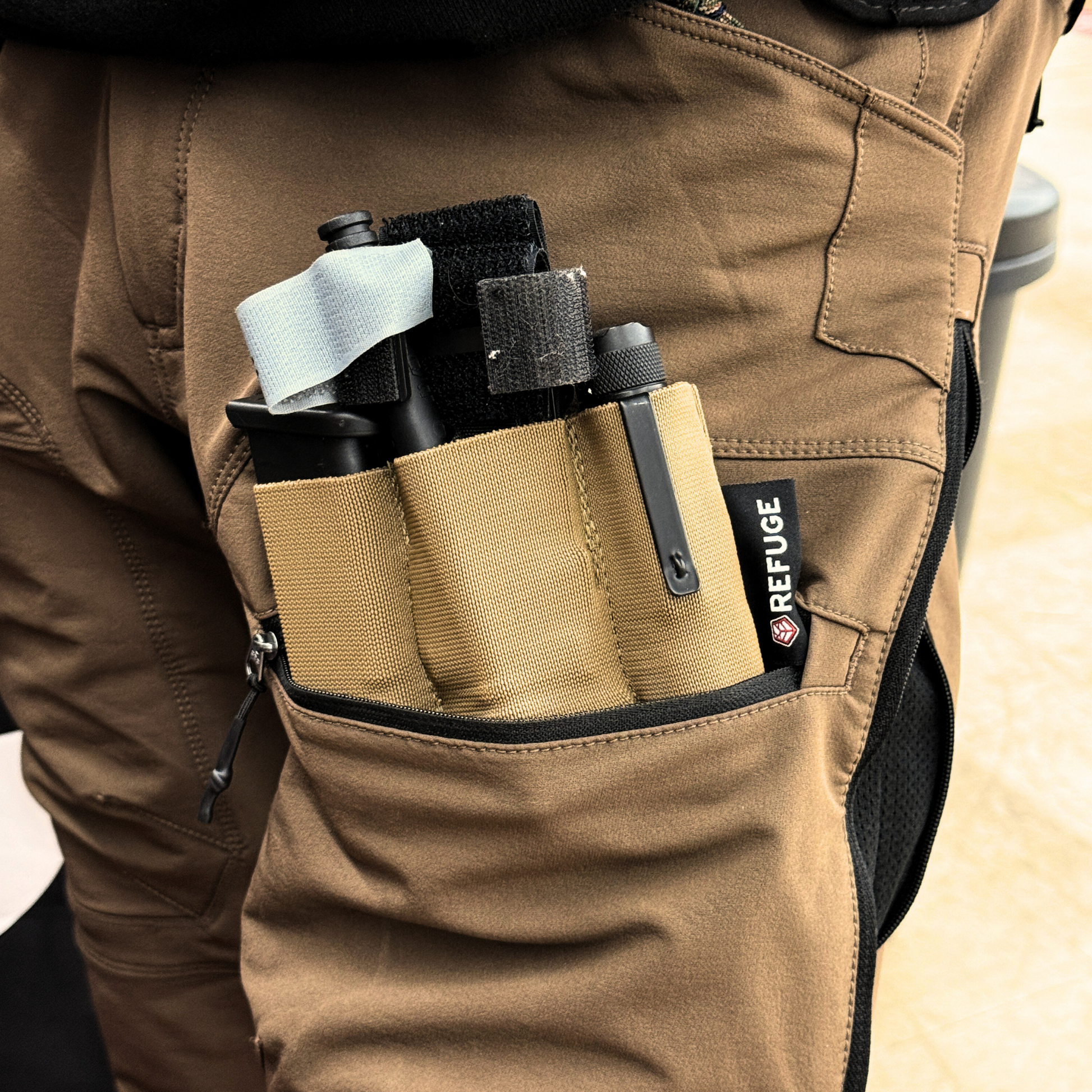 Refuge Medical Pocket Organizer - Coyote Tan in a cargo pocket packed with magazine, tourniquet, and flashlight (components not included)